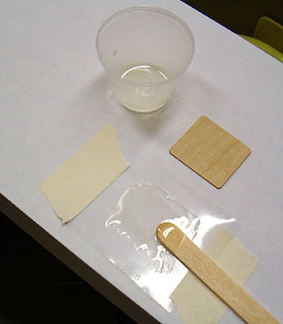 Tape a piece of wax paper down.  Apply epoxy to the wax paper.