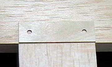 A plywood plate is inset into the sheeting to support the wing bolts.