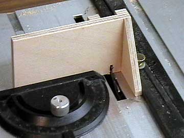 The fixture uses the compound slide to push it through the table saw.