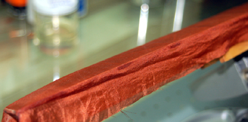 The silk is tacked to the trailing edge at several locations.